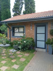 a brick house with a blue garage door at Net 'n Bed in Middelburg