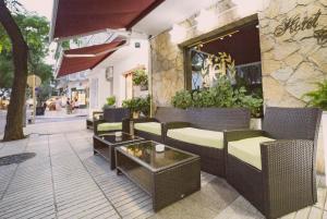 a patio with chairs and tables on a building at Hotel Medium Claramar in Platja  d'Aro