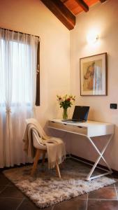 a desk with a laptop on it in a room with a window at Piccola casa vacanze - Small vacation house in Porto Valtravaglia