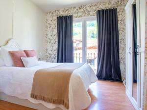 ein Schlafzimmer mit einem Bett und einem Fenster in der Unterkunft La Casa de Ethel en norte de España VV-2427-AS in Cangas de Onís