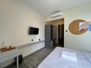 a bedroom with a bed and a tv on a wall at Cove Legacy in Jakarta