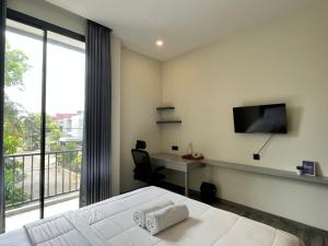 a bedroom with a bed and a desk and a tv at Cove Legacy in Jakarta