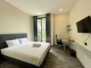 a bedroom with a bed and a desk and a television at Cove Legacy in Jakarta