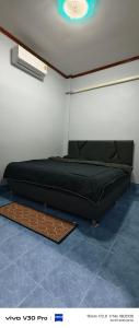 a black bed in a room with a ceiling at Jatuporn in Betong