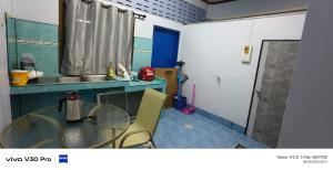 una cucina con tavolo in vetro e lavandino di Jatuporn a Betong Altre 3 foto