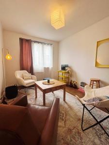 una sala de estar con un sofá y una mesa en Parenthèse à l'Oasis, en Ploërmel 2 fotos más