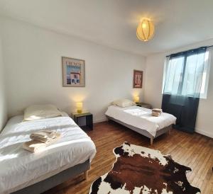 dos camas en una habitación con dos mesas y una habitación con dos camas en Parenthèse à l'Oasis, en Ploërmel