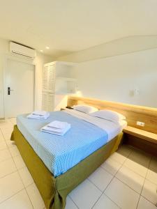 a bedroom with a bed with two towels on it at Hotel Mavridis in Flogita