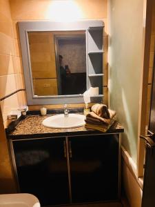 um banheiro com uma pia e um espelho em Corniche Apartments em Casablanca