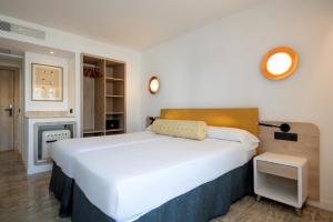 a bedroom with a large white bed and a fireplace at Hotel Foners in Playa de Palma +45 photos