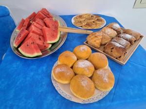 a table topped with plates of bread and watermelons and pastries at Hotel Ponte in Vieste