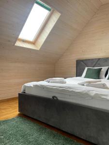 ein Schlafzimmer mit einem großen Bett mit Dachfenster in der Unterkunft Freedom23 in Solotschyn
