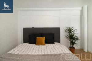 a bedroom with a bed with a yellow pillow on it at Loftas Dumu fabrikas in Vilnius