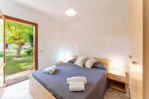 a bedroom with a bed with towels on it at Le Dimore di Budoni in Budoni