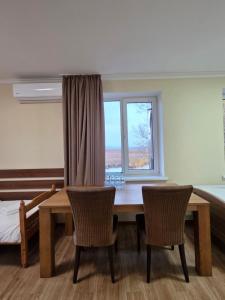 uma mesa de jantar com 2 cadeiras e uma janela em Carpe Diem em Chistilov mais 30 fotografias