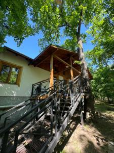 a house with a fence next to a tree at кемпінг-парк Метеорит in Orlovshchina +6 photos