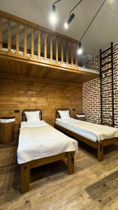 two beds in a room with wooden walls at кемпінг-парк Метеорит in Orlovshchina