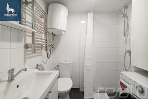 a white bathroom with a toilet and a sink at Loftas Dumu fabrikas in Vilnius