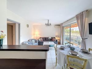 een woonkamer met een tafel en een bank bij Nice family apartment close to the beach in Le Lavandou