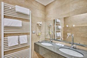 a bathroom with a sink and a mirror at Hotel Tre Ville in Parma +91 photos