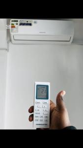 a person holding a remote control in their hand at Shalom Apartment in Lusaka