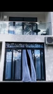 a window with a curtain on a building at Shalom Apartment in Lusaka