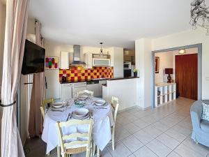 een keuken en eetkamer met een tafel en stoelen bij Nice family apartment close to the beach in Le Lavandou