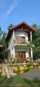 a large white house with a balcony and stairs at Cinnamon garden villa ahangama in Ahangama