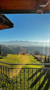 a view of a green field from a balcony at Willa Sulejowka in Poronin