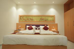 a bedroom with a large bed with two white pillows at Winspark Inn Resort in Varkala +26 photos