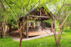 a house with a wooden deck in the woods at Lodge Forest Suite in Hluhluwe