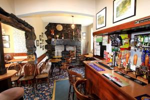 a bar in a restaurant with a stone fireplace at The Eagles Bunkhouse in Betws-y-coed