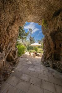a stone walkway with an umbrella and a patio at Villa Enea in Poggiardo
