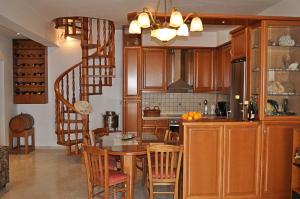 a kitchen with wooden cabinets and a table with chairs at Villa Agalianos in Kerames