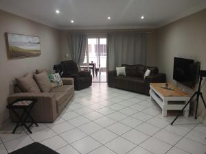 Una sala de estar con dos sofás y un televisor. en Perfect holiday destination!, en Jeffreys Bay