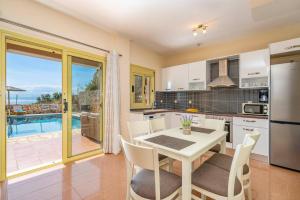 a kitchen with a table and a kitchen with a view at Villa Apollon by Villa Plus in Spathíon