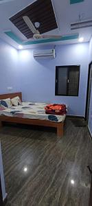 Un dormitorio con una cama y un televisor de pantalla plana. en karthikfamilyguesthouse, en Hampi