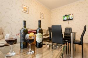 two bottles of wine on a table with two glasses at Comfort retreat in Tbilisi City