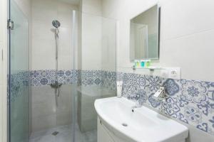 a bathroom with a glass shower and a sink at Comfort retreat in Tbilisi City +8 photos