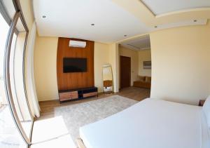 a bedroom with a bed and a flat screen tv at Villa with Private Pool in Marrakech - Dar Mazar in Oubadine
