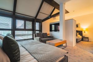 a bedroom with a bed and a living room at Great Polonia The Granary La Suite Hotel in Wrocław