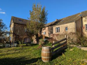 Un edificio antiguo con un barril delante. en Saisonnée, en Centrès 28 fotos más