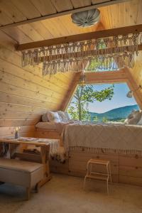 a bedroom in a log cabin with a bed and a window at Alemiło mini - domek z balią i widokiem na Babią Górę in Zawoja