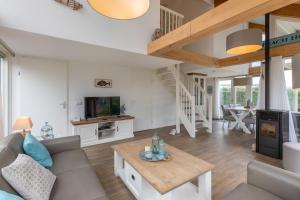 a living room with a couch and a table at Zonnedorp 18 Duinhuis Renesse | Relaxte strandvakantie voor het hele gezin in Renesse