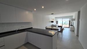 a kitchen with white cabinets and a dining room at Casa Reinolds in El Pozo del Esparto