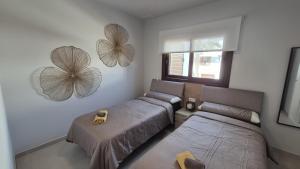 a bedroom with two beds and a window and mirrors at Casa Reinolds in El Pozo del Esparto +30 photos