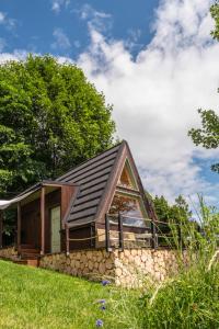 a house on a hill with a stone wall at Alemiło mini - domek z balią i widokiem na Babią Górę in Zawoja +45 photos