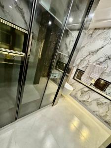 a bathroom with a shower and a marble wall at 3BR Modern Home Fast Wi-Fi & Parking DHA 9 in Lahore +9 photos
