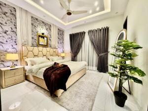 a bedroom with a bed and a plant in it at 3BR Modern Home Fast Wi-Fi & Parking DHA 9 in Lahore