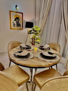 a wooden table with plates and napkins on it at 3BR Modern Home Fast Wi-Fi & Parking DHA 9 in Lahore